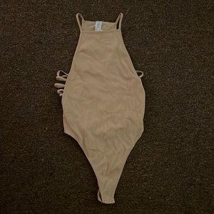 Open sided body suit! This is stretchy comfortable material. Never worn. Beige